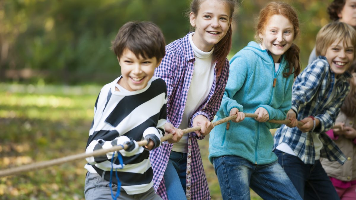 group of children playing tug of war and laughing