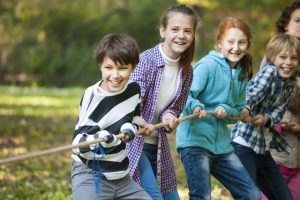 group of children playing tug of war and laughing